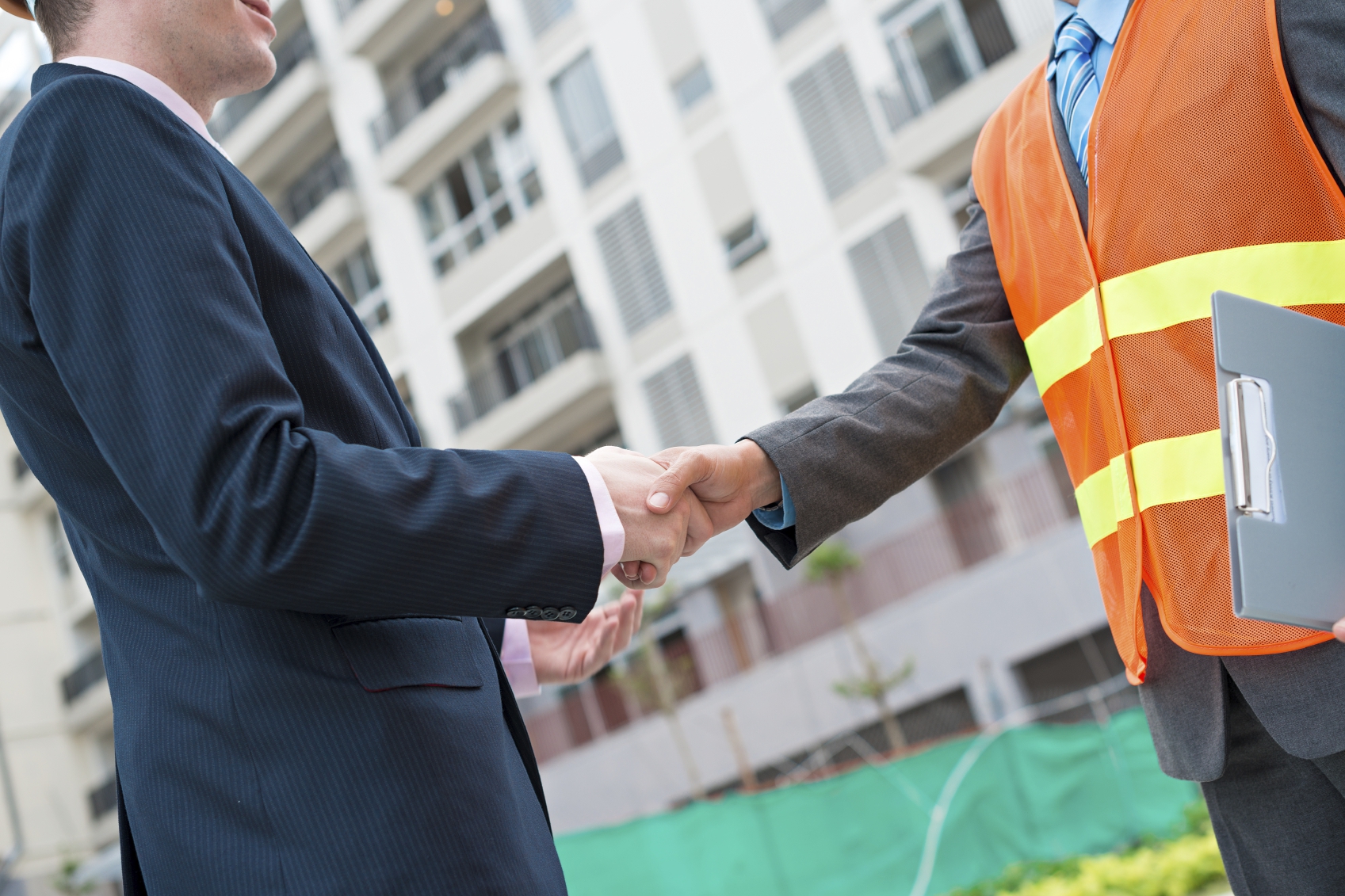 Cropped Image of Businessman Shaking Hands with Construction Worker
